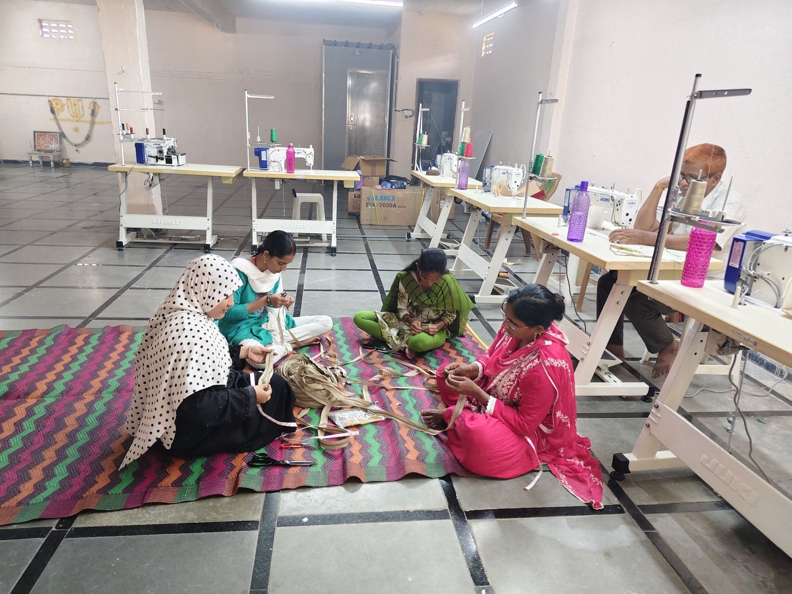 HuskWorks artisans hand-stitching jute bags together on the workshop floor